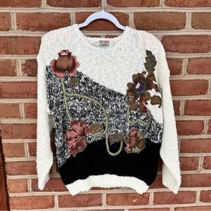 Black and white sweater with embroidered floral and gold ribbon design. size M